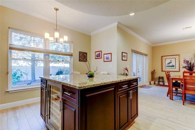 kitchen featuring wine cooler, visible vents, baseboards, decorative light fixtures, and crown molding