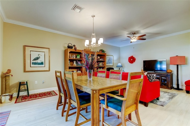 dining room featuring light wood-style floors, baseboards, visible vents, and crown molding