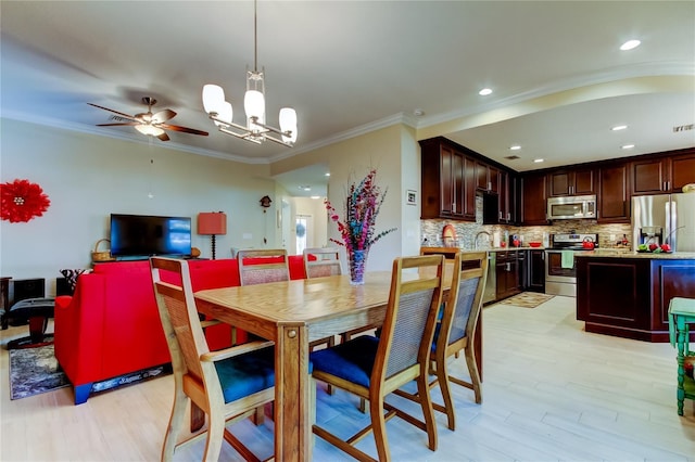 dining area with light wood finished floors, recessed lighting, visible vents, crown molding, and ceiling fan with notable chandelier