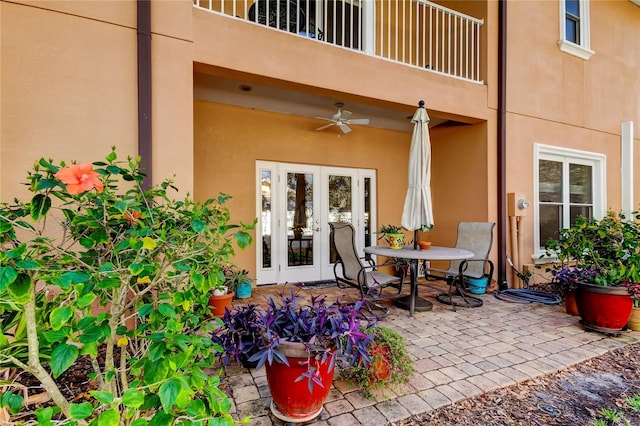 view of patio featuring a balcony, a ceiling fan, and french doors