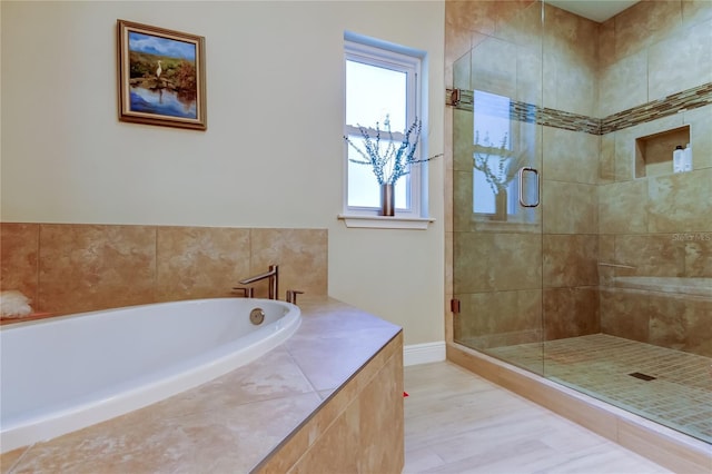 bathroom featuring a shower stall, baseboards, and a bath