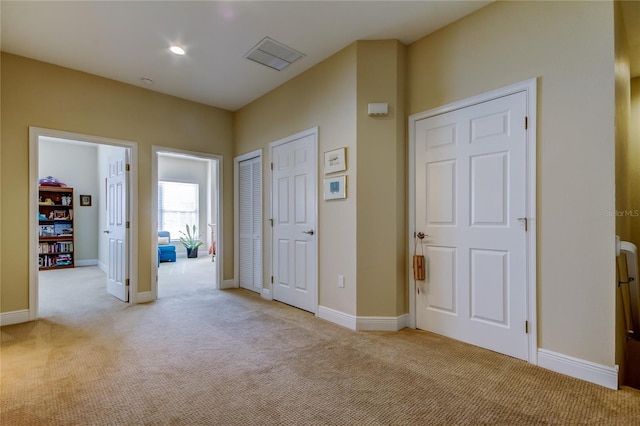 hall with light carpet, visible vents, baseboards, and recessed lighting