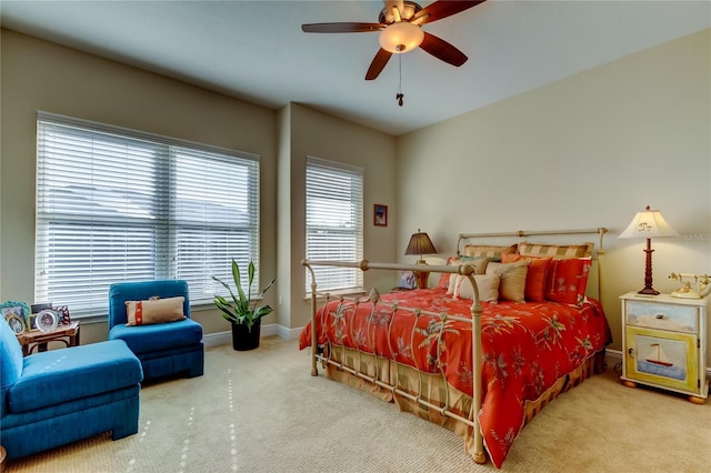 bedroom with a ceiling fan, baseboards, and carpet flooring