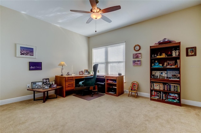 office area with baseboards, a ceiling fan, and light colored carpet