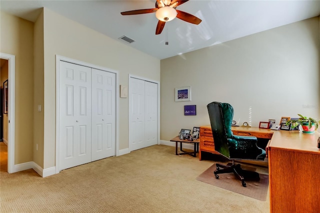 office space featuring light carpet, ceiling fan, visible vents, and baseboards