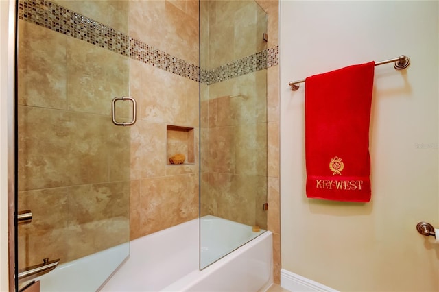 bathroom with baseboards and bath / shower combo with glass door