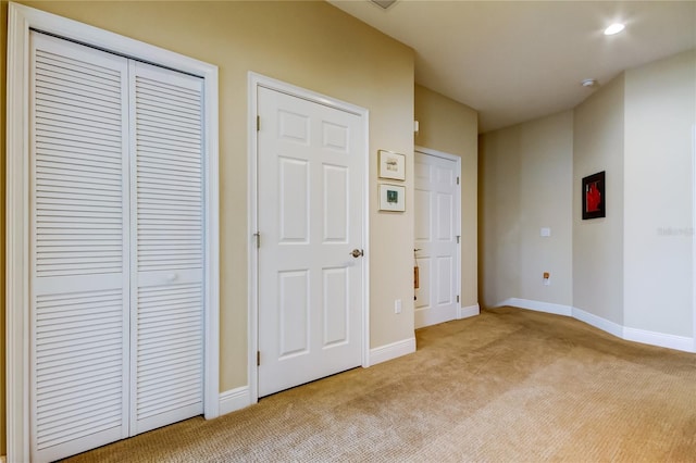 unfurnished bedroom with recessed lighting, baseboards, and light colored carpet