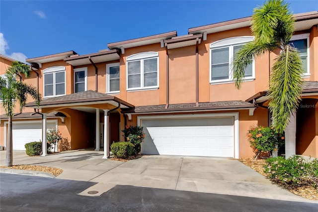 multi unit property with an attached garage, concrete driveway, and stucco siding