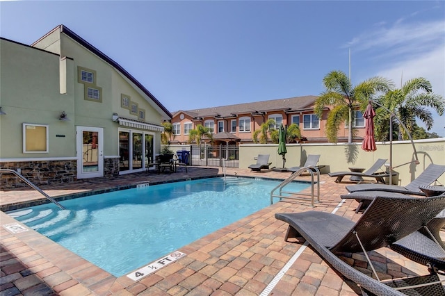 pool with a patio area and fence