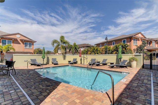 pool featuring a patio area, a residential view, and fence