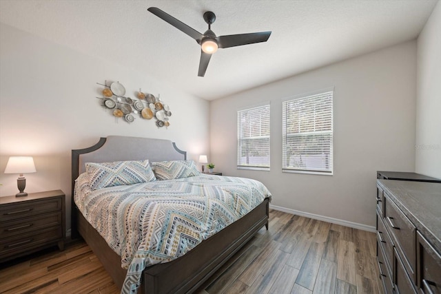 bedroom featuring wood finished floors, a ceiling fan, and baseboards