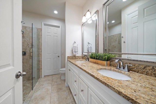 bathroom featuring tile patterned floors, a sink, toilet, and walk in shower