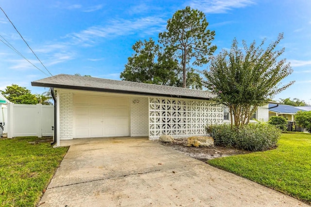 garage with concrete driveway and fence