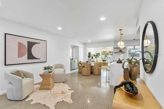 living area with recessed lighting, speckled floor, baseboards, and visible vents