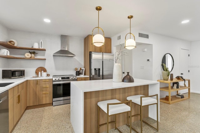 kitchen with visible vents, stainless steel appliances, light speckled floor, wall chimney exhaust hood, and modern cabinets