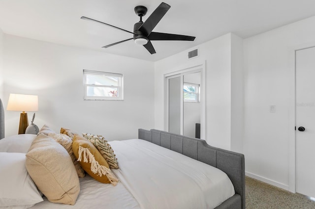 bedroom with multiple windows, carpet, visible vents, and ceiling fan