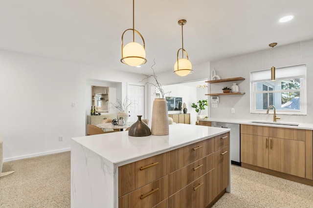 kitchen featuring a sink, light countertops, dishwasher, light speckled floor, and a center island