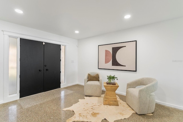 sitting room featuring recessed lighting, speckled floor, and baseboards