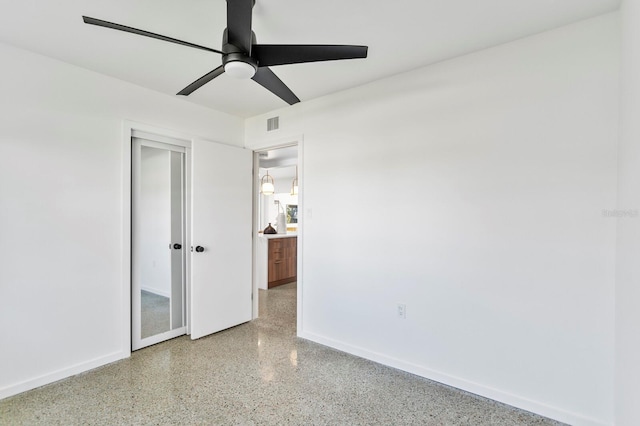 unfurnished bedroom featuring visible vents, a ceiling fan, a closet, speckled floor, and baseboards