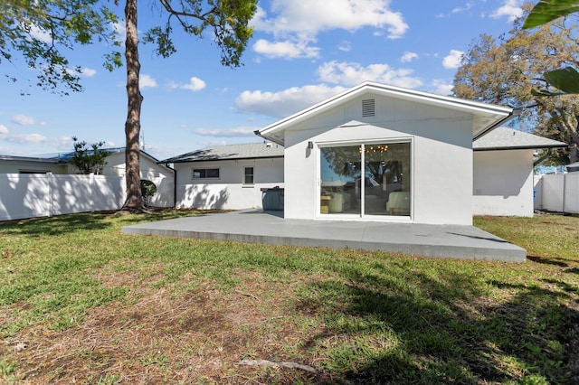 rear view of house with a patio, a yard, and fence