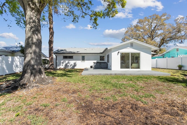 back of property with a yard, a patio area, a fenced backyard, and stucco siding