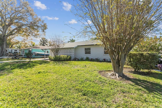 view of home's exterior featuring an attached garage, a lawn, and brick siding