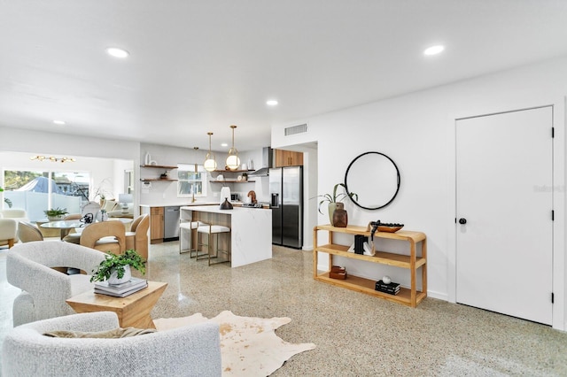 living area featuring light speckled floor, recessed lighting, and visible vents