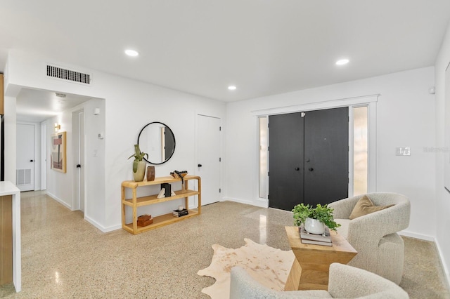 living area with speckled floor, recessed lighting, visible vents, and baseboards