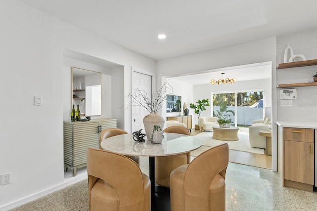 dining area with a notable chandelier, recessed lighting, light speckled floor, and baseboards