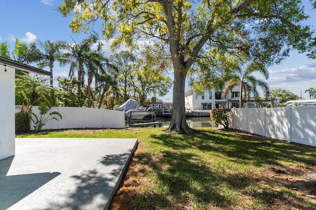 view of yard featuring a patio, fence, and a boat dock