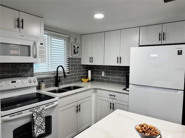 kitchen with white cabinetry, sink, backsplash, white appliances, and light stone counters