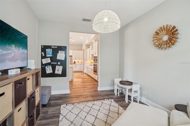living area featuring baseboards, a chandelier, dark wood-type flooring, and visible vents