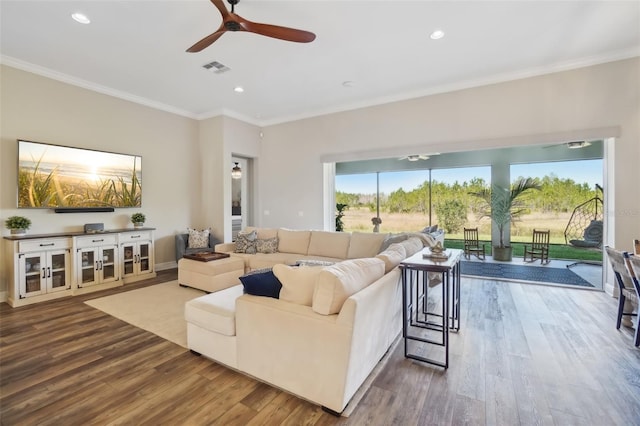 living area featuring visible vents, recessed lighting, a ceiling fan, wood finished floors, and ornamental molding