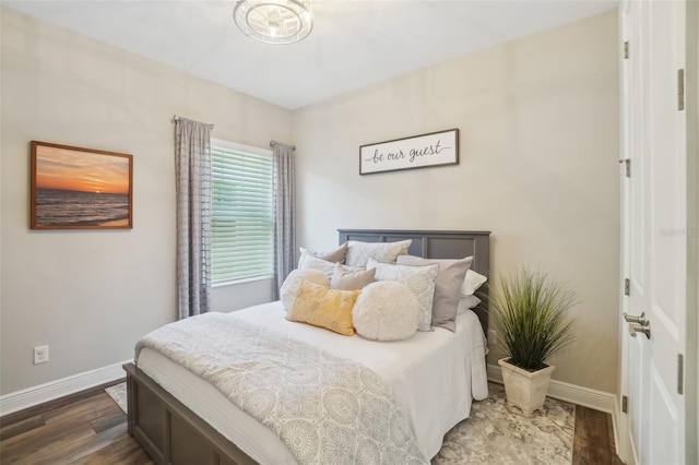 bedroom with wood finished floors and baseboards
