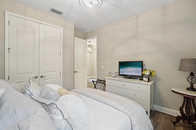 bedroom with baseboards, visible vents, a closet, and dark wood-style flooring