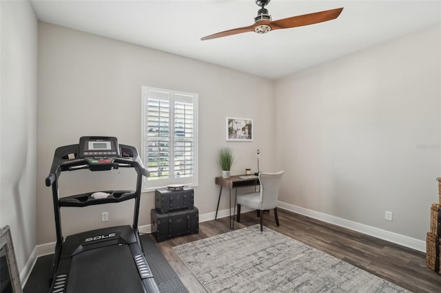 workout room with baseboards, a ceiling fan, and wood finished floors