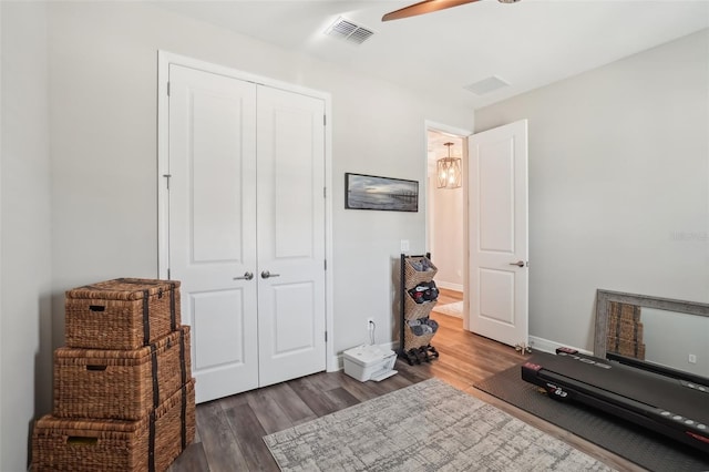exercise area featuring wood finished floors, visible vents, baseboards, and ceiling fan