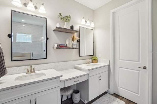 full bath featuring walk in shower, wood finished floors, a sink, and double vanity