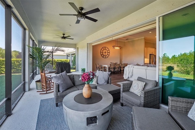 sunroom featuring a ceiling fan and an outdoor living space