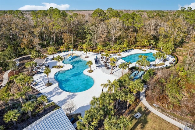 view of swimming pool with a forest view
