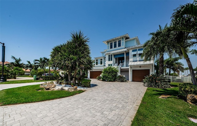 raised beach house featuring a garage and a front yard