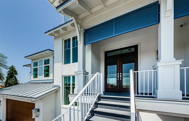 view of exterior entry with a garage and french doors