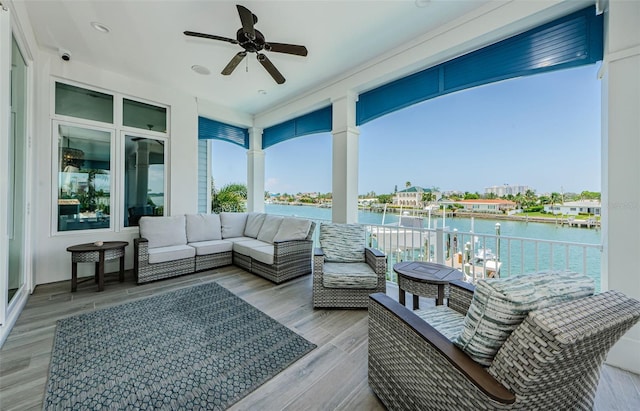 wooden deck with ceiling fan, a water view, and an outdoor hangout area