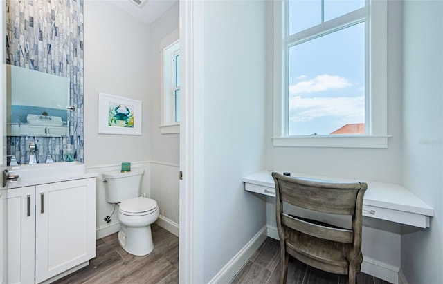 bathroom featuring toilet, vanity, and hardwood / wood-style floors