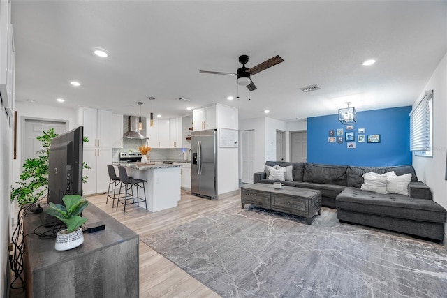 living room featuring ceiling fan and light hardwood / wood-style flooring