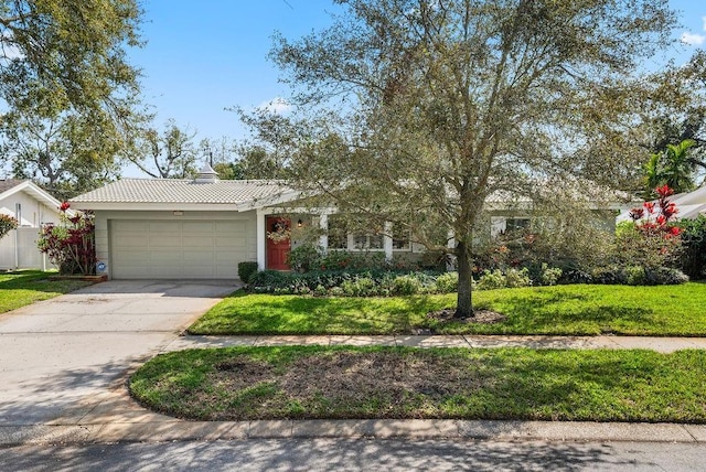 view of front of property featuring a garage, driveway, and a front yard