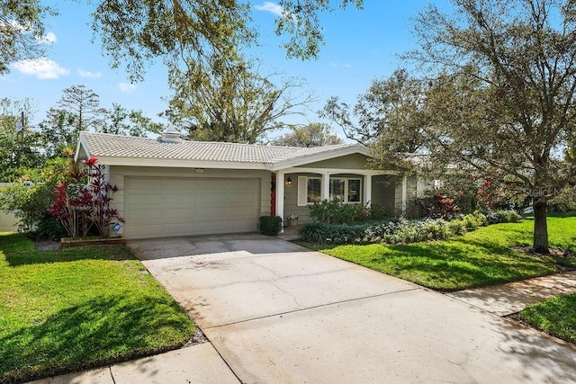 view of front of home featuring a garage, concrete driveway, and a front lawn