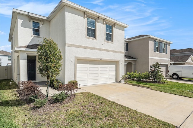 traditional home featuring driveway, an attached garage, and stucco siding