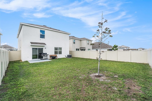 rear view of property featuring a patio area, a fenced backyard, a yard, and stucco siding