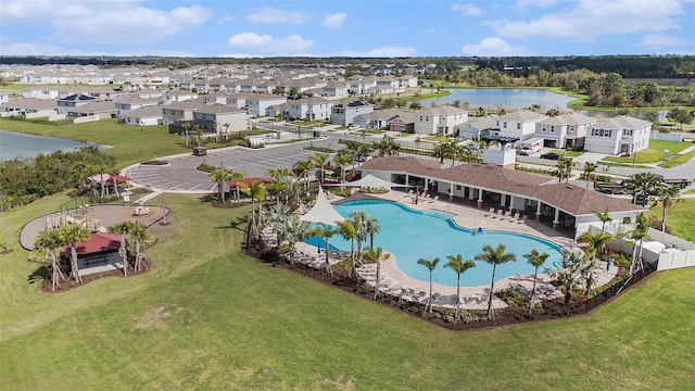 community pool with a residential view, a water view, and fence